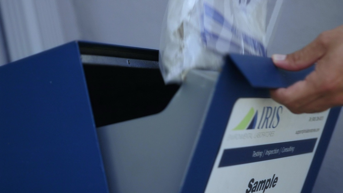 A sealed sample bag being placed into the IRIS sample drop box at the Union, NJ laboratory